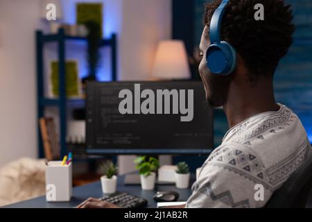 It code developer wearing headset programming codes for firewall server on computer working remote from home. Hacker man typing infographics javascript writing artificial intelligence algorithm Stock Photo
