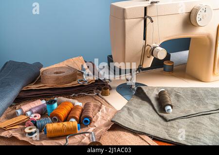 Sewing machine, thread and fabric. Designer workplace sewing machine in the office. Stock Photo