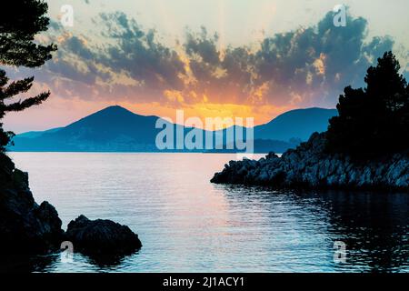 Dramatic sunset over the mountains and the sea in Budva Stock Photo