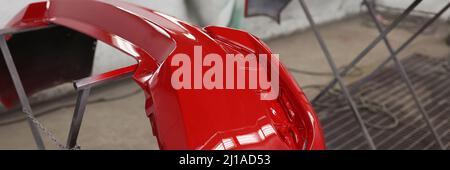 Painted red bumpers to drying in workshop closeup Stock Photo