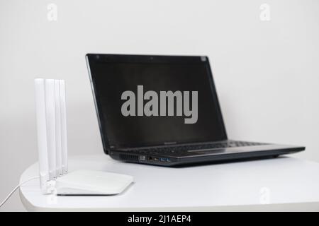 Laptop and wi-fi router on a white background. Internet connection. Stock Photo