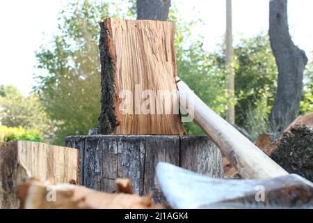 Heavy axe lies on the firewood Stock Photo