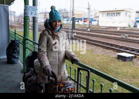 A young woman from Ukraine with luggage is seen in Przemysil train station, close to the border with Ukraine, where refugees arrive by train as they f Stock Photo