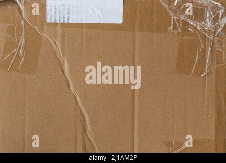 Worn cardboard texture with clear tape and white blank sticker Stock Photo