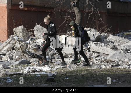Mariupol, Ukraine. 23rd Mar, 2022. People pass by a damaged building in Mariupol, Ukraine, March 23, 2022. Credit: Victor/Xinhua/Alamy Live News Stock Photo
