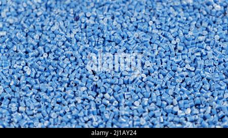 Secondary granule made of polypropylene, Blue Plastic pellets crumbles to the table. Plastic raw materials in granules for industry. Polymer resin Stock Photo