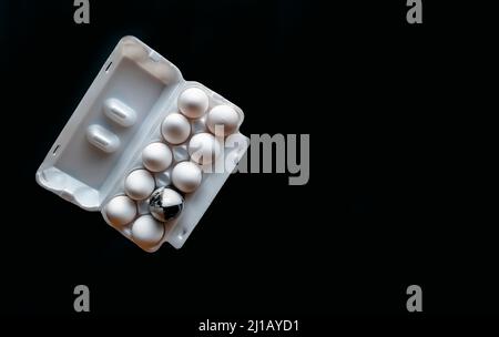 Fresh chicken eggs closeup on a black background. marble stone egg on a background of white chicken eggs Stock Photo