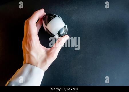 marble stone egg in hand on a black background. Easter theme Stock Photo