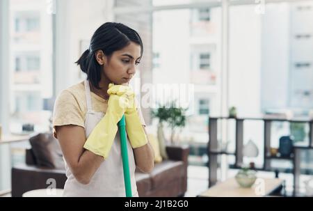 Sometimes the sparkle isnt there no matter what I do. Shot of a young woman looking unhappy while cleaning her home. Stock Photo