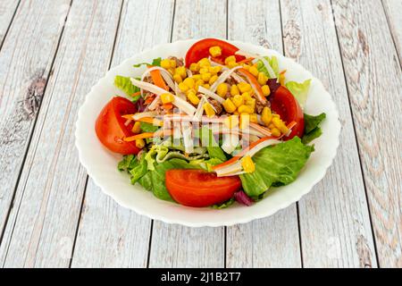 This mixed salad is made up of romaine lettuce, tomato, carrot, surimi, onion, sweet corn, and boiled egg. Stock Photo