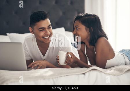 Laughing together is the best form of intimacy. Shot of a young couple using a laptop. Stock Photo