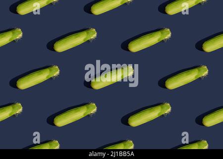 A green ear of corn. Juicy corn of a new harvest. Seamless pattern. Blue background. Stock Photo