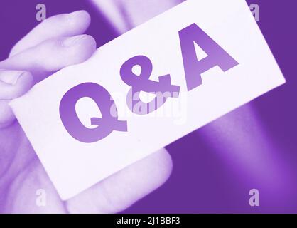 Q and A Questions and Answers sign on business card shown by a businessman,. Business concept Stock Photo