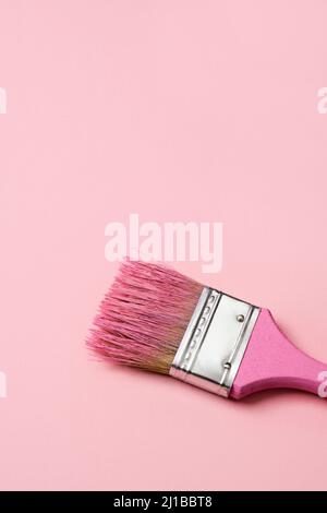 Premium Photo  New and used paintbrushes in a vase on a pink background  with copy space