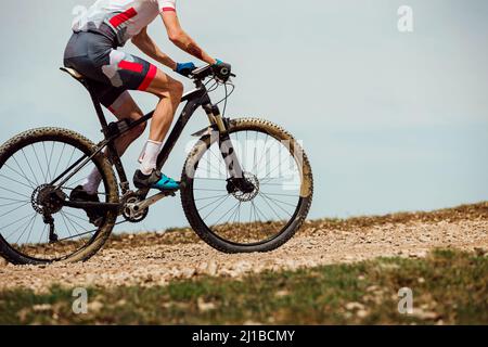 athlete cyclist riding mountain bike uphill Stock Photo