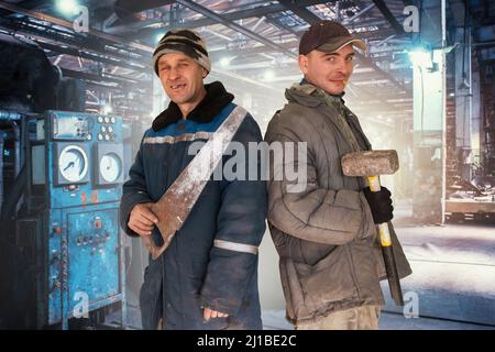 Two bad unskilled workers in bad dirty tattered uniform with bad tools. Concept of unskilled workers or crooks or poor quality workers Stock Photo