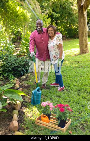 Portrait of happy african american senior couple gardening in backyard Stock Photo