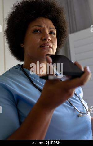 African american mid adult female nurse talking on phone call in hospital Stock Photo