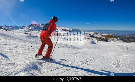 Man skiing with sun and mountain in Sierra Nevada, Granada. Stock Photo