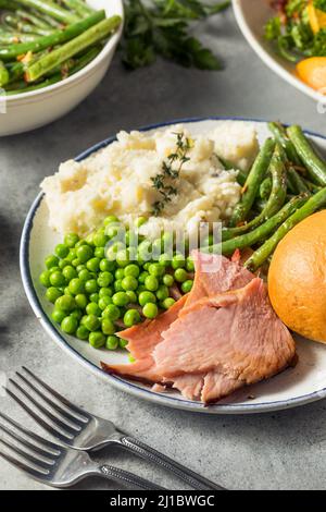 Homemade Easter Ham Dinner with Pototoes Beans and Peas Stock Photo