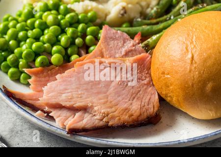 Homemade Easter Ham Dinner with Pototoes Beans and Peas Stock Photo