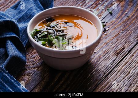 Pumpkin soup with coconut milk and seeds, vegan plant based meal Stock Photo