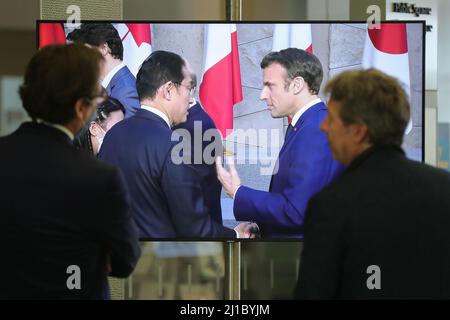 Brussels, Belgium. 24th Mar, 2022. People watch a screen displaying Japanese Prime Minister Fumio Kishida and French President Emmanuel Macron attending a photo session during a meeting of G7 Leaders at the NATO headquarters in Brussels, Belgium, March 24, 2022. Credit: Zheng Huansong/Xinhua/Alamy Live News Stock Photo