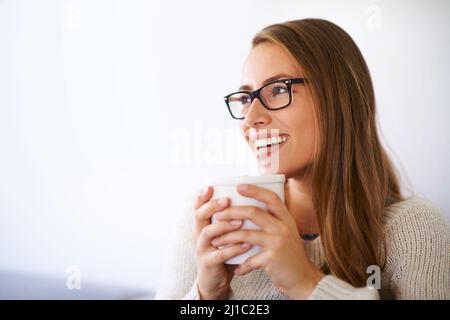 Easing into the day with a nice cup of coffee. Shot of a young woman having coffee at home. Stock Photo