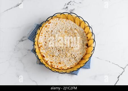 Punjabi breakfast naan kulcha in a basket isolated on napkin side view on grey background famous indian and pakistani food Stock Photo