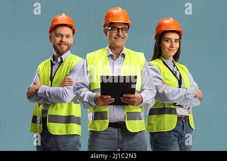 Team of three site engineers isolated on blue background Stock Photo