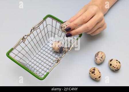 female hand puts quail eggs in a basket. High quality photo Stock Photo