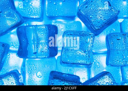 Ice cubes with blue backlight in the freezer close-up in full screen selective focus Stock Photo
