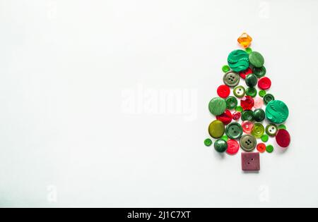 Tree made of buttons of green, red color. white background, copy space. Creative Christmas Concept or gardening. Stock Photo