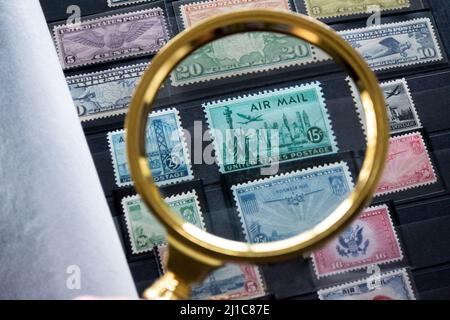 Moscow, Russia, March 2022: Hobbies: collecting and exploring postage stamps. An album with old stamps. Looking at the green stamp with Statue of Libe Stock Photo