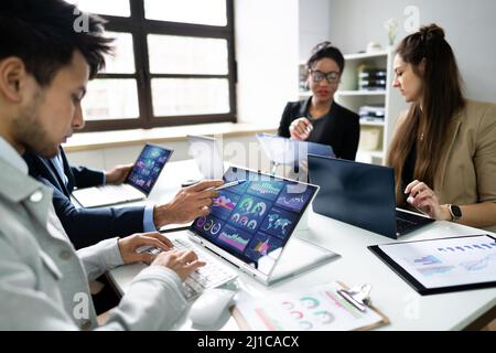 Side View Of Businesspeople Examining Graph On Computer At Workplace Stock Photo