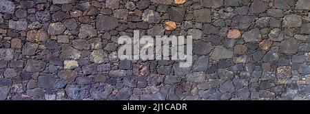 Panoramic stone wall made of volcanic rock Stock Photo