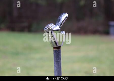 Drinking fountain in the middle of a park with a blurred nature and grass background. Stock Photo