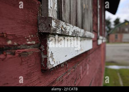 Paint on barn wall decaying, up close of wood window trim. Stock Photo