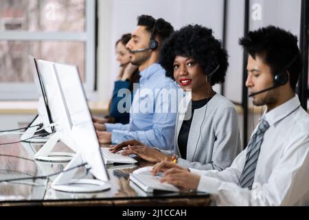 Positive Customer Services Agent With Headset Working In A Call Center Stock Photo