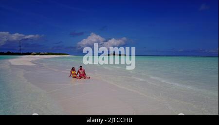 A young romantic couple relaxing on the tropical beach, Rasdhoo Island, The Maldives Stock Photo