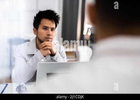 Female Manager Interviewing A Young Male Applicant Stock Photo