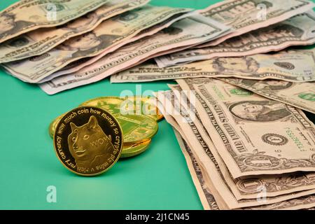 A pile of dollars and a few dogecoin on a green table. Photograph in horizontal format. Stock Photo