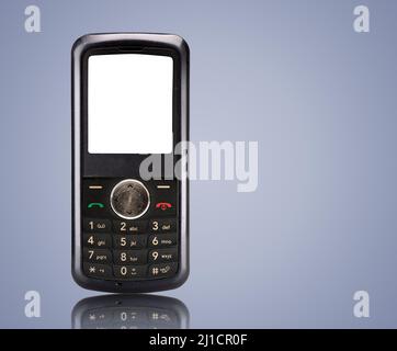 Old push-button mobile phone with a reflection on a blue background Stock Photo