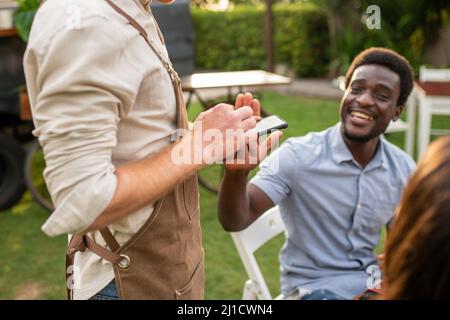 Cheerful black man using smartphone in park Stock Photo