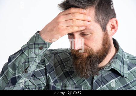 Upset man standing with his hand holding his forehead Stock Photo