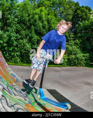 young boy going airborne with his scooter Stock Photo