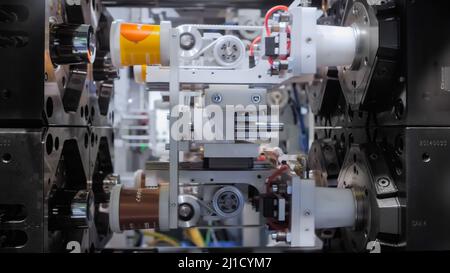 Injection molding machine during work: production of empty plastic pots ...