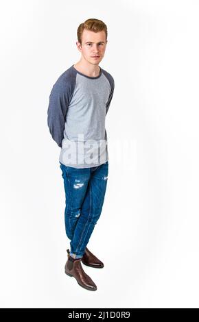Stylish handsome man posing sitting on floor. Handsome Guy. cool fashion  male model sitting on grey background and looking at the camera. Student in  a Stock Photo - Alamy
