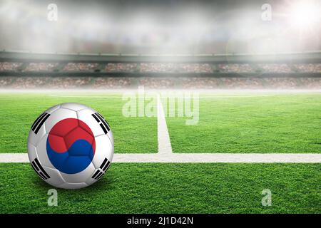 Football in brightly lit outdoor stadium with painted flag of South Korea. Focus on foreground and soccer ball with shallow depth of field on backgrou Stock Photo