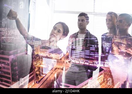 Re-evaluating plans to reinvent the city. Multiple exposure shot of a group of businesspeople working on plans superimposed over a city. Stock Photo